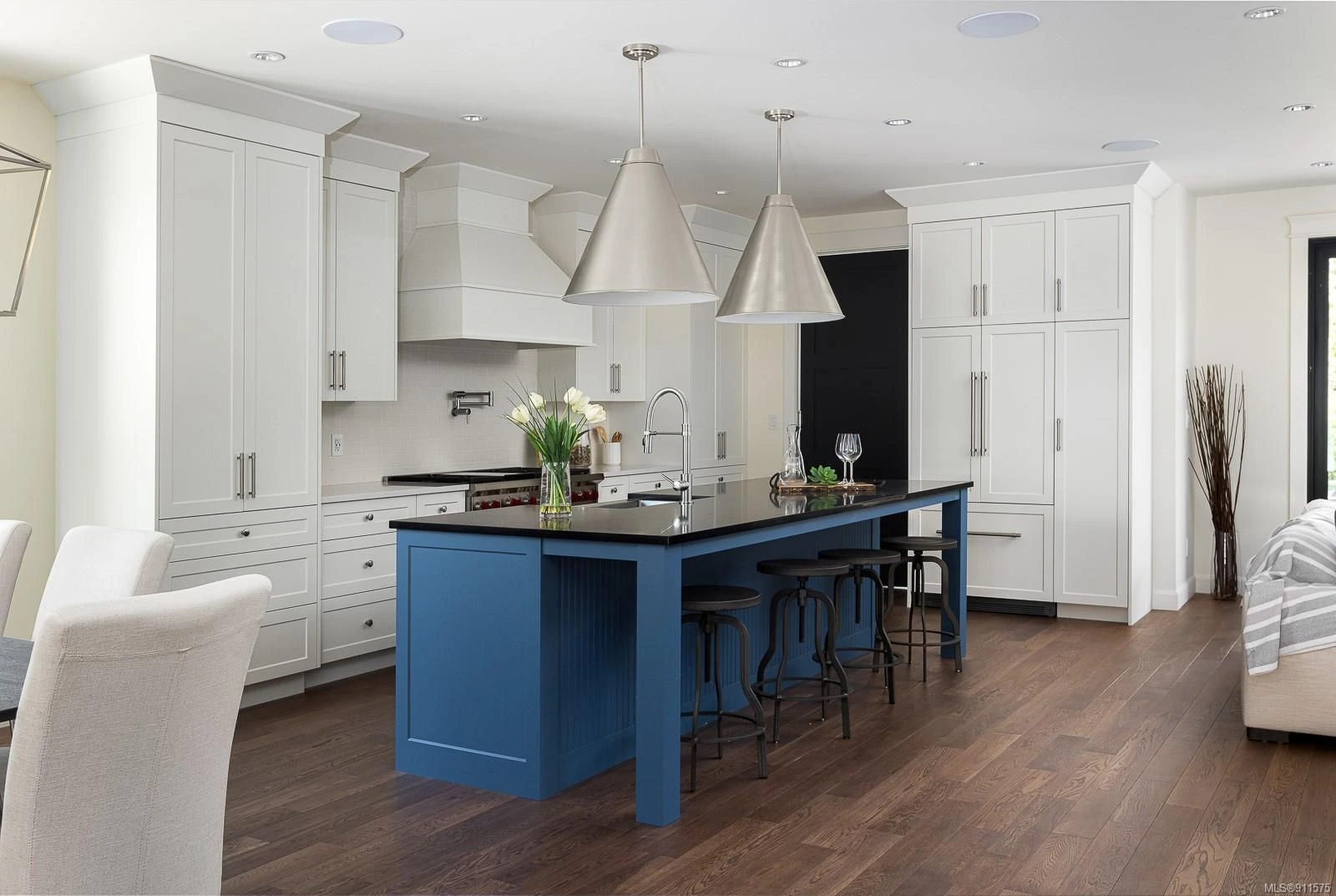 Custom white cabinetry with striking blue island and premium finishes