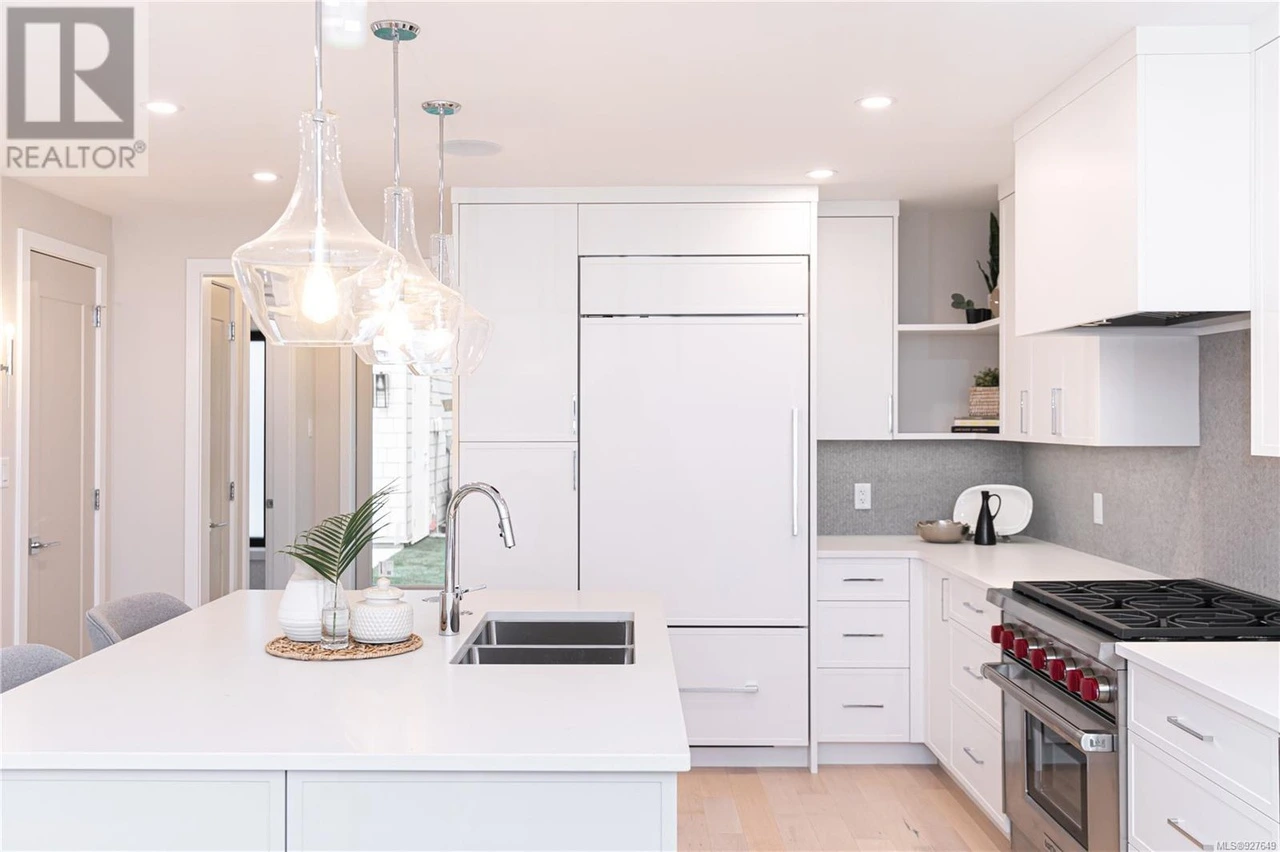 Central island with pendant lighting connecting to dining area with clean lines